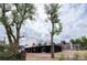 A modern home with black and white siding and a roof deck, surrounded by mature trees at 5462 S Cedar St, Littleton, CO 80120