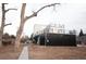 View of the side and rear of a modern home with black metal siding and white upper level at 5462 S Cedar St, Littleton, CO 80120