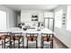 Bright kitchen features a large island, modern white cabinets, and sleek black bar stools at 5462 S Cedar St, Littleton, CO 80120