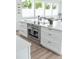 Modern kitchen featuring stainless steel appliances, a central island, and stylish white cabinetry at 5462 S Cedar St, Littleton, CO 80120
