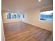 Bright living room featuring many windows, white walls, and wood-look flooring at 5462 S Cedar St, Littleton, CO 80120