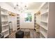Well-organized walk-in closet with custom shelving, a decorative chandelier, and ample storage space at 5462 S Cedar St, Littleton, CO 80120