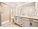 Bathroom featuring large walk-in glass shower, double vanity sinks, and ample storage at 8409 Rush Creek Ave, Littleton, CO 80125