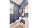 Stylish powder room with blue accent wall, patterned rug, pedestal sink and wood storage at 8409 Rush Creek Ave, Littleton, CO 80125