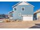 Beautiful blue home exterior with attached garage and well-maintained landscaping at 8409 Rush Creek Ave, Littleton, CO 80125