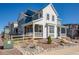 Charming two-story home with white siding and a covered porch, complemented by rocky landscaping at 8409 Rush Creek Ave, Littleton, CO 80125