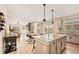 Open kitchen and living area featuring a spacious island, modern appliances, and wood floors at 8409 Rush Creek Ave, Littleton, CO 80125