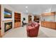 Basement with a fireplace, built-in bookshelves, a wet bar, a stationary bike and comfortable seating at 9916 Sand Cherry Way, Highlands Ranch, CO 80129
