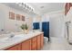 Bright bathroom showcasing a double sink vanity, framed artwork, decorative plants and a tub shower at 9916 Sand Cherry Way, Highlands Ranch, CO 80129