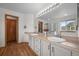 Bright bathroom with double sinks, wood-look floors, and a large vanity at 9916 Sand Cherry Way, Highlands Ranch, CO 80129