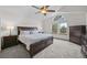 Spacious bedroom with large windows, a ceiling fan, and elegant dark wood furniture at 9916 Sand Cherry Way, Highlands Ranch, CO 80129