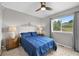 Cozy bedroom featuring a large window with backyard view, side tables, and a ceiling fan at 9916 Sand Cherry Way, Highlands Ranch, CO 80129