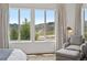 A scenic view of the mountains from the bedroom of the house with a cozy chair at 15490 W Asbury Ave, Lakewood, CO 80228