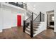 Grand two-story foyer featuring a red front door, modern lighting, and hardwood flooring at 15490 W Asbury Ave, Lakewood, CO 80228