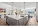 A kitchen island with quartz countertops, cabinets, and hardwood floors is the focal point at 15490 W Asbury Ave, Lakewood, CO 80228