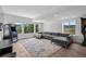 Open-concept living room with hardwood floors, large windows offering tons of natural light, and neutral decor at 15490 W Asbury Ave, Lakewood, CO 80228