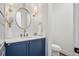 Charming powder room featuring modern fixtures, stylish wallpaper, and a blue vanity at 15490 W Asbury Ave, Lakewood, CO 80228