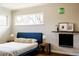 Stylish bedroom featuring a blue bed frame, hardwood floors, and a decorative fireplace at 3501 W 41St Ave, Denver, CO 80211