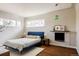 Bedroom with a blue bed frame, hardwood floors, fireplace, and bright windows for natural lighting at 3501 W 41St Ave, Denver, CO 80211