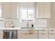 Bright kitchen featuring white cabinets, quartz countertops, stainless steel appliances, and a window overlooking the backyard at 3501 W 41St Ave, Denver, CO 80211