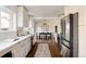 Open kitchen with stainless steel appliances and a view into the adjacent dining area with hardwood floors at 3501 W 41St Ave, Denver, CO 80211