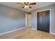 Bedroom with hardwood floors, gray walls, ceiling fan, and closet featuring dark doors at 10900 Mildred Dr, Northglenn, CO 80233