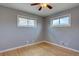 Bright bedroom featuring hardwood floors, gray walls, and natural light from two windows at 10900 Mildred Dr, Northglenn, CO 80233
