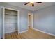 Bedroom with hardwood floors and open closet featuring shelving and rod for storage at 10900 Mildred Dr, Northglenn, CO 80233