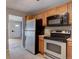 Well-lit kitchen featuring stainless steel appliances, wood cabinets, and durable tile flooring at 10900 Mildred Dr, Northglenn, CO 80233