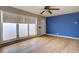 Bright living room featuring hardwood floors, a ceiling fan, and large windows for ample natural light at 10900 Mildred Dr, Northglenn, CO 80233