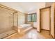 Bathroom showcasing a glass-enclosed shower and soaking tub with tile surround and natural light at 9096 E Colorado Cir, Denver, CO 80231