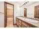 Bathroom highlighting dual sinks, granite counters, a shower stall, and wooden doors at 9096 E Colorado Cir, Denver, CO 80231
