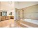 Primary bath featuring tub, shower, double vanity, and beautiful natural light at 9096 E Colorado Cir, Denver, CO 80231