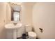 Classic half bath with pedestal sink, toilet, and a framed mirror at 9096 E Colorado Cir, Denver, CO 80231