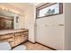 Bathroom featuring a sink with granite countertop, vanity with storage, and a window with natural light at 9096 E Colorado Cir, Denver, CO 80231