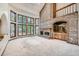 Bright living room features a brick fireplace, large windows with views, and an open concept design at 9096 E Colorado Cir, Denver, CO 80231