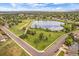 Aerial view of houses next to a grassy area with a walking path surrounding a lake at 10832 W Powers Pl, Littleton, CO 80127