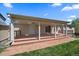 Covered back patio with a doorway and sliding glass door and a brick walkway at 10832 W Powers Pl, Littleton, CO 80127