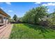 Grassy backyard with a brick walkway connected to the covered back patio at 10832 W Powers Pl, Littleton, CO 80127