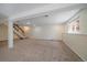 Unfinished basement with stairs, carpet, and a window allowing natural light at 10832 W Powers Pl, Littleton, CO 80127