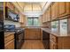 Galley kitchen with light wood cabinetry, updated countertops, and stainless steel appliances at 10832 W Powers Pl, Littleton, CO 80127