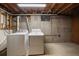 Unfinished laundry room with washer and dryer next to the concrete foundation and small window at 10832 W Powers Pl, Littleton, CO 80127