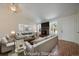 Bright living room with vaulted ceilings, fireplace, and large windows, virtually staged at 10832 W Powers Pl, Littleton, CO 80127