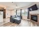 Comfortable living space with fireplace, large windows, and stylish gray furnishings and wood-look floors at 16320 E Fremont Ave # 1, Aurora, CO 80016