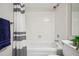 Well-lit bathroom featuring white tiles, safety bar, and striped shower curtain at 205 Wright St # 104, Lakewood, CO 80228