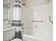 Well-lit bathroom with a shower and tub featuring white tiles, safety bar, and striped shower curtain at 205 Wright St # 104, Lakewood, CO 80228
