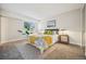 A well-lit bedroom featuring a plush bed with stylish bedding, side tables with lamps, and neutral carpeting at 205 Wright St # 104, Lakewood, CO 80228