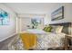 Bright bedroom showcasing a well-dressed bed, side tables, and a large indoor plant by the window at 205 Wright St # 104, Lakewood, CO 80228