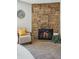 Close-up of stone fireplace with a comfy chair nearby at 205 Wright St # 104, Lakewood, CO 80228