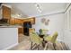 A kitchen and dining area, featuring wooden cabinets, a black refrigerator, and a glass table set with four chairs at 205 Wright St # 104, Lakewood, CO 80228